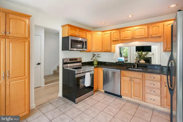 a kitchen with stainless steel appliances granite countertop a refrigerator and a sink
