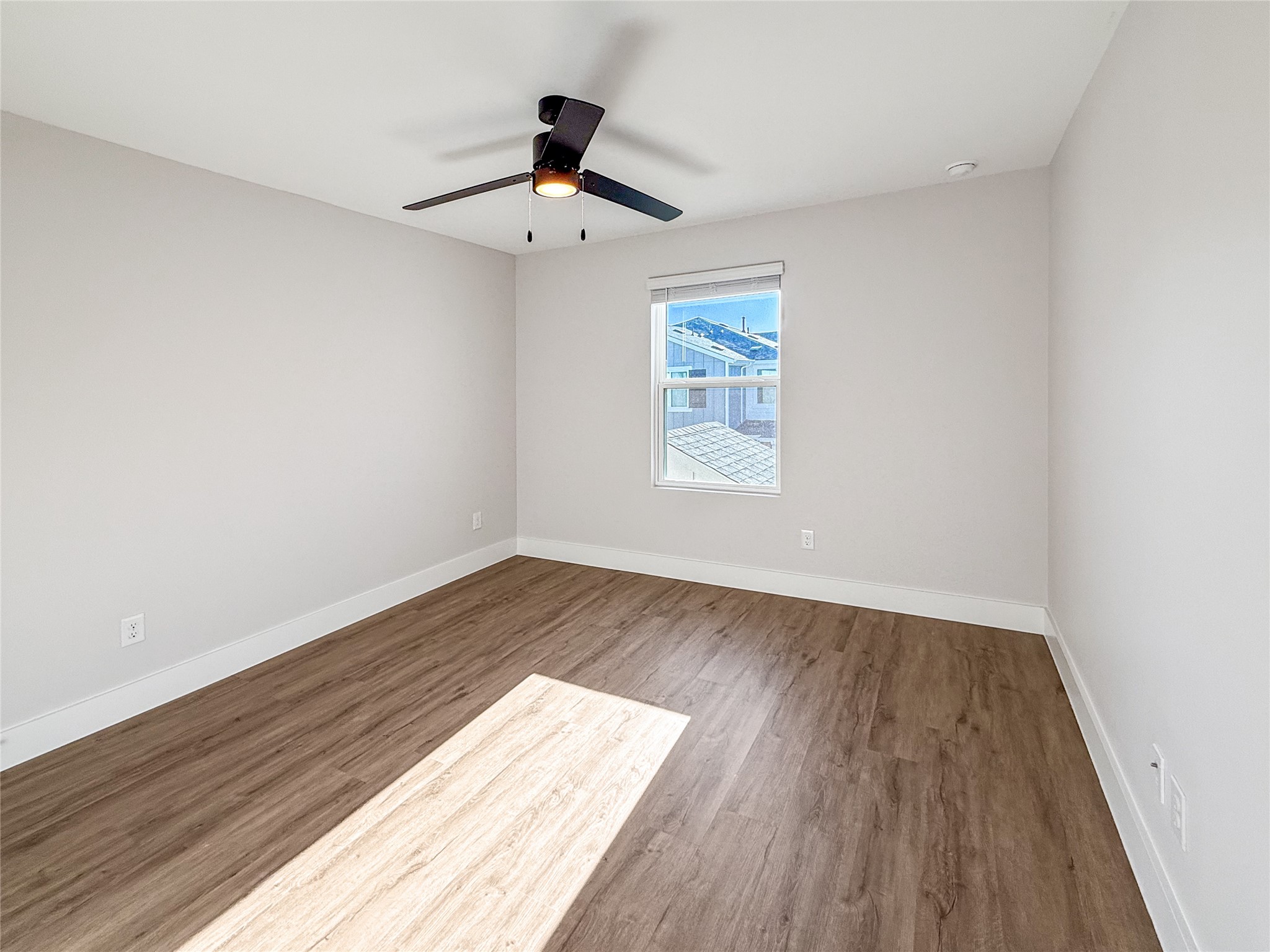 5611 Mobeetie Loop Bee Cave, TX 78738 - Photo 13 of 22 an empty room with wooden floor chandelier fan and windows
