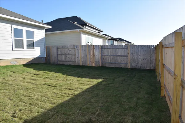 a view of a lake with a yard and large trees