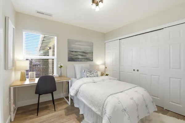 a bedroom with a bed and a lamp on dresser