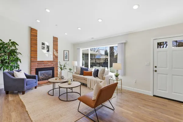 a living room with furniture a fireplace and a potted plant