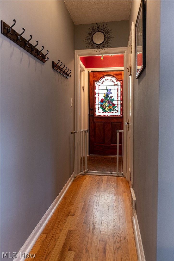 3433 Bradford Road Cleveland, OH 44118 - Photo 25 of 35 Viewed from the side dr & kitchen, shows off the beautiful front dr, w/ original stained glass in the foyer. A coat closet is to the right of the front door. The white dr on right, before the gate, is a convenient 1/2 Bth. Theirs also a dr to the right(not shown), that is a lg storage pantry.