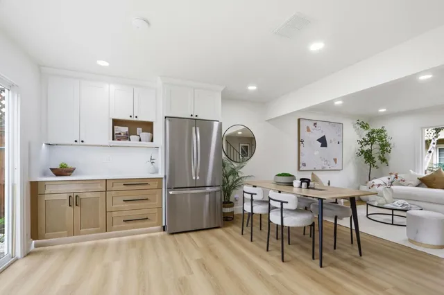 a kitchen with granite countertop a refrigerator a stove a sink a dining table and chairs