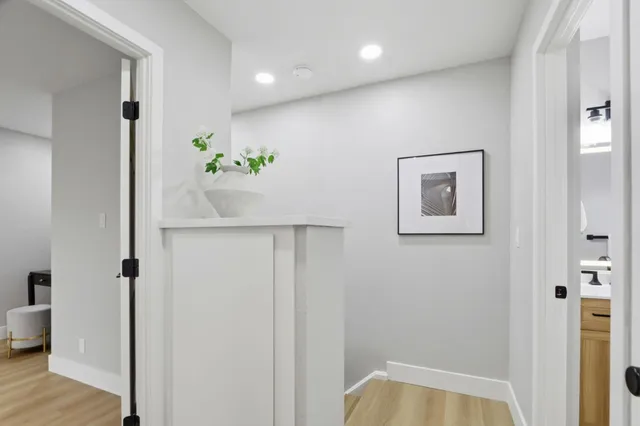 a view of hallway with plant and wooden floor