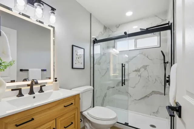 a bathroom with a sink a toilet and shower