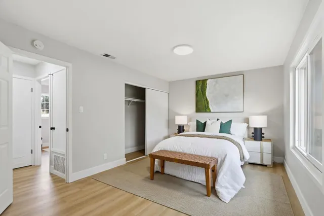 a bedroom with a bed table and a window