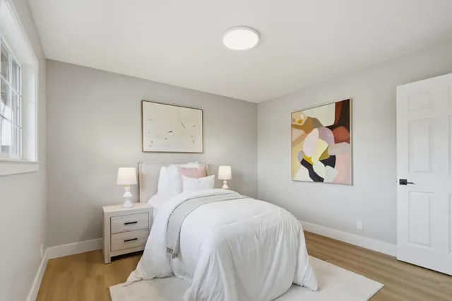 a bedroom with a bed and painting on the wall