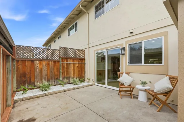 a view of a patio with a table and chairs and floor to ceiling window