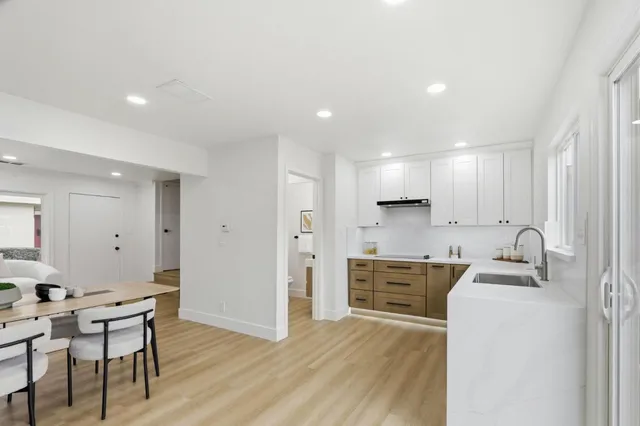 a kitchen with kitchen island a stove a sink a refrigerator and cabinets