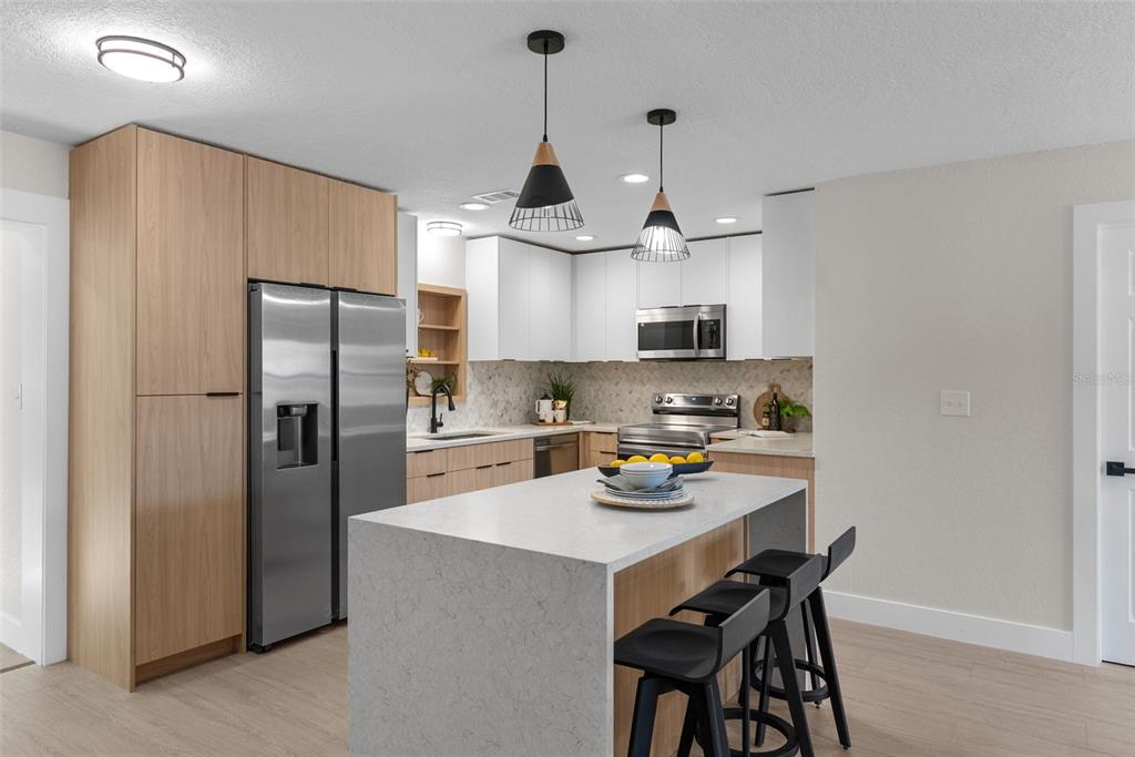 12368 70th Street Largo, FL 33773 - Photo 11 of 33 a kitchen with stainless steel appliances granite countertop a refrigerator a sink dishwasher a stove and a refrigerator with wooden floor
