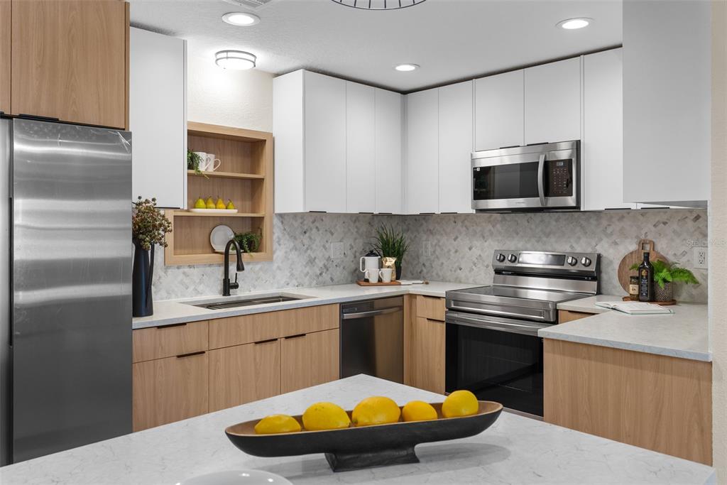 12368 70th Street Largo, FL 33773 - Photo 13 of 33 a kitchen with stainless steel appliances a sink a stove a microwave a sink and cabinets