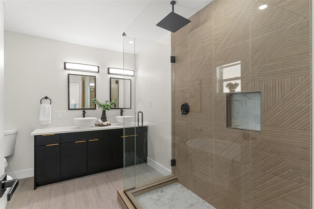 12368 70th Street Largo, FL 33773 - Photo 19 of 33 a bathroom with a double vanity sink a mirror and a bathtub