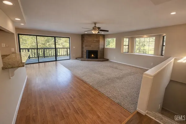 a view of an empty room with a window and fireplace