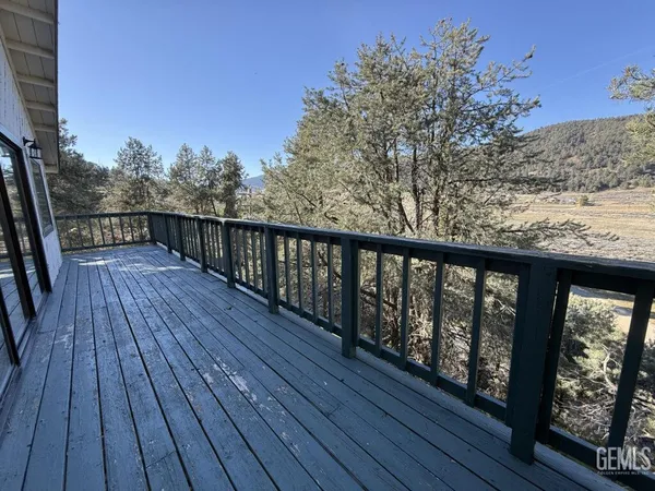 a balcony with wooden floor and city view