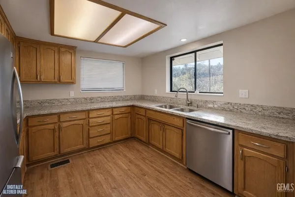 a kitchen with granite countertop cabinets stainless steel appliances a sink and a large window