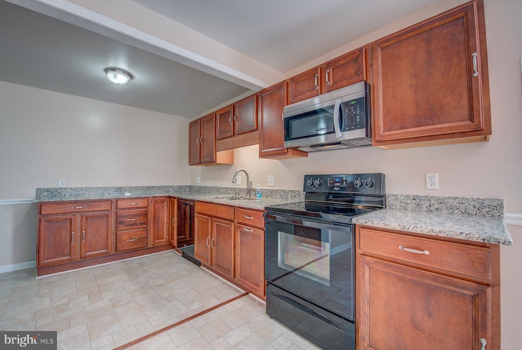 10605 Willetts Crossing Road White Plains, MD 20695 - Photo 3 of 22 a kitchen with stainless steel appliances granite countertop a stove microwave and sink