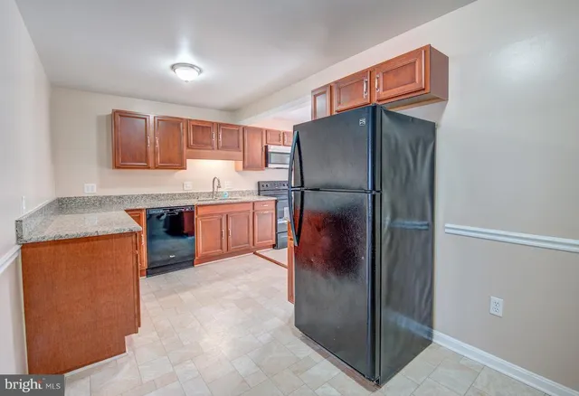 a kitchen with stainless steel appliances granite countertop a refrigerator and a stove