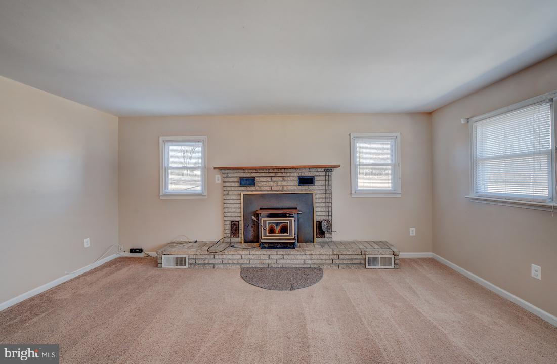 10605 Willetts Crossing Road White Plains, MD 20695 - Photo 6 of 22 wooden floor and fireplace in empty room