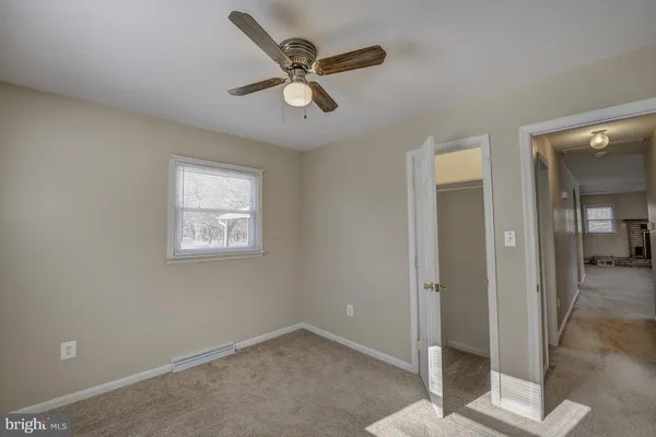 a view of a livingroom with a ceiling fan and window