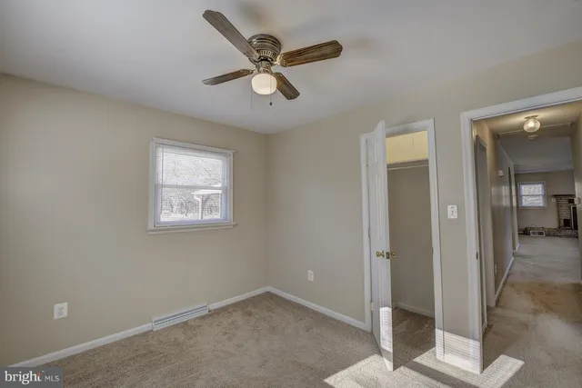 a view of a livingroom with a ceiling fan and window