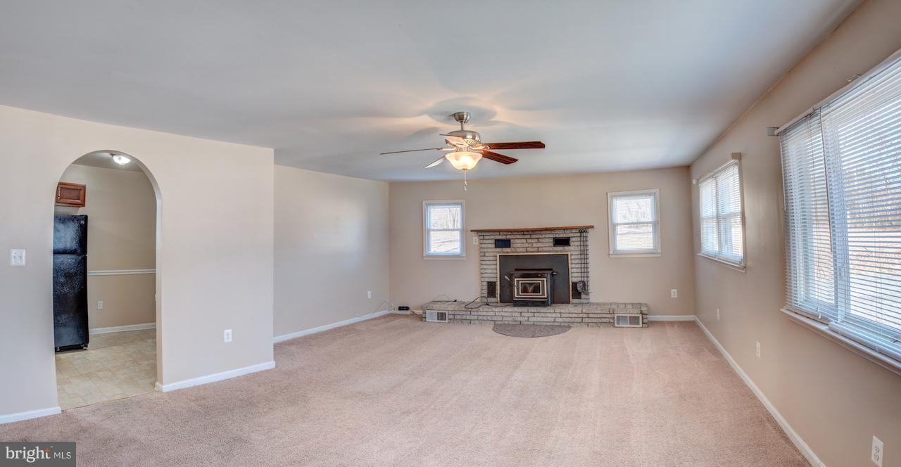10605 Willetts Crossing Road White Plains, MD 20695 - Photo 10 of 22 a view of a livingroom with a fireplace a ceiling fan and windows