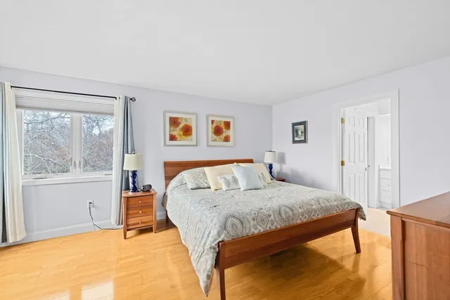 a bedroom with a bed and large windows