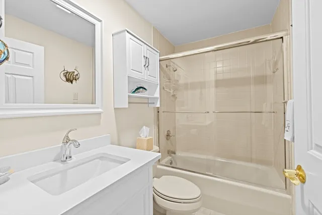 a bathroom with a bathtub shower sink vanity and toilet