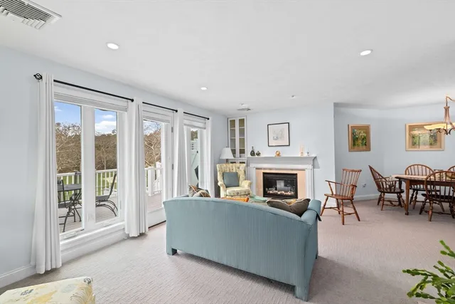 a living room with furniture a fireplace and a floor to ceiling window