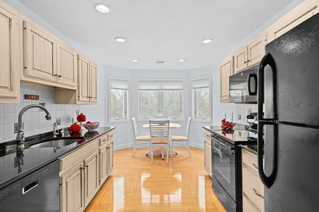 a kitchen with stainless steel appliances granite countertop a refrigerator sink and white cabinets