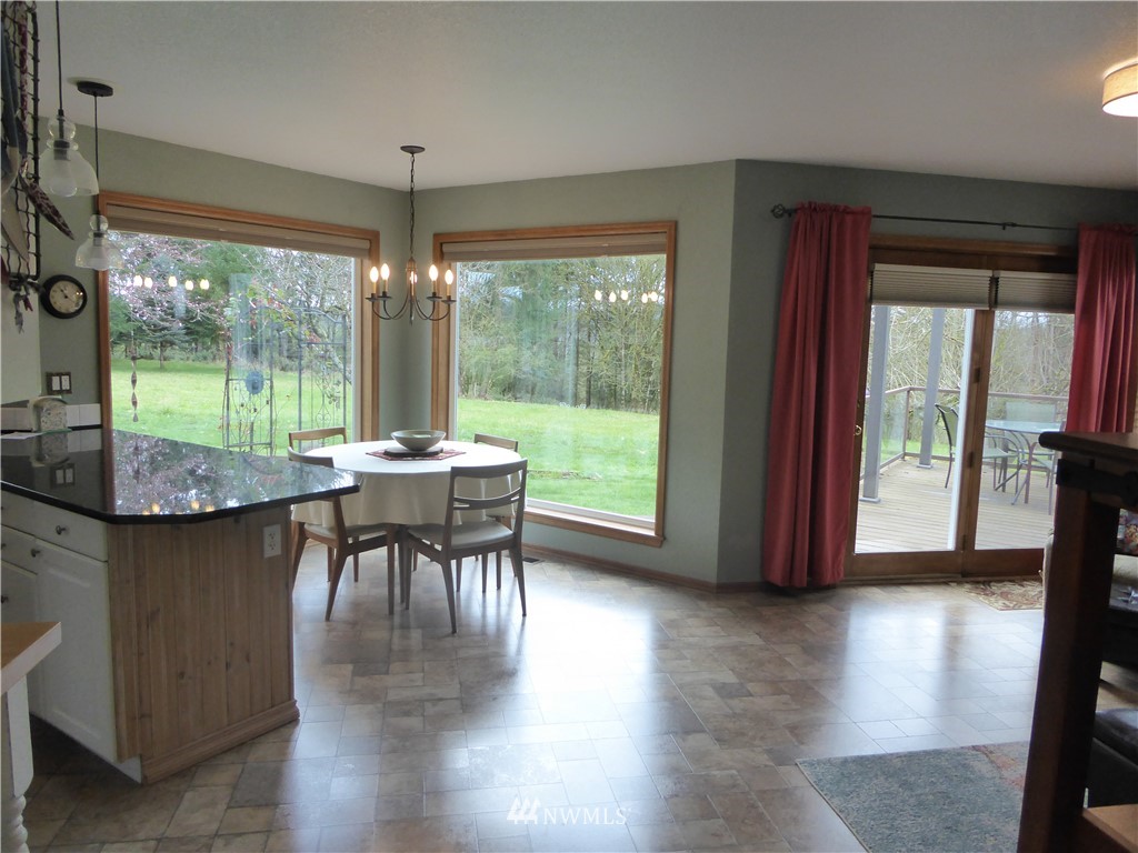 9527 Gastaeson Lane Southwest Rochester, WA 98579 - Photo 10 of 40 a dining room with furniture and a floor to ceiling window