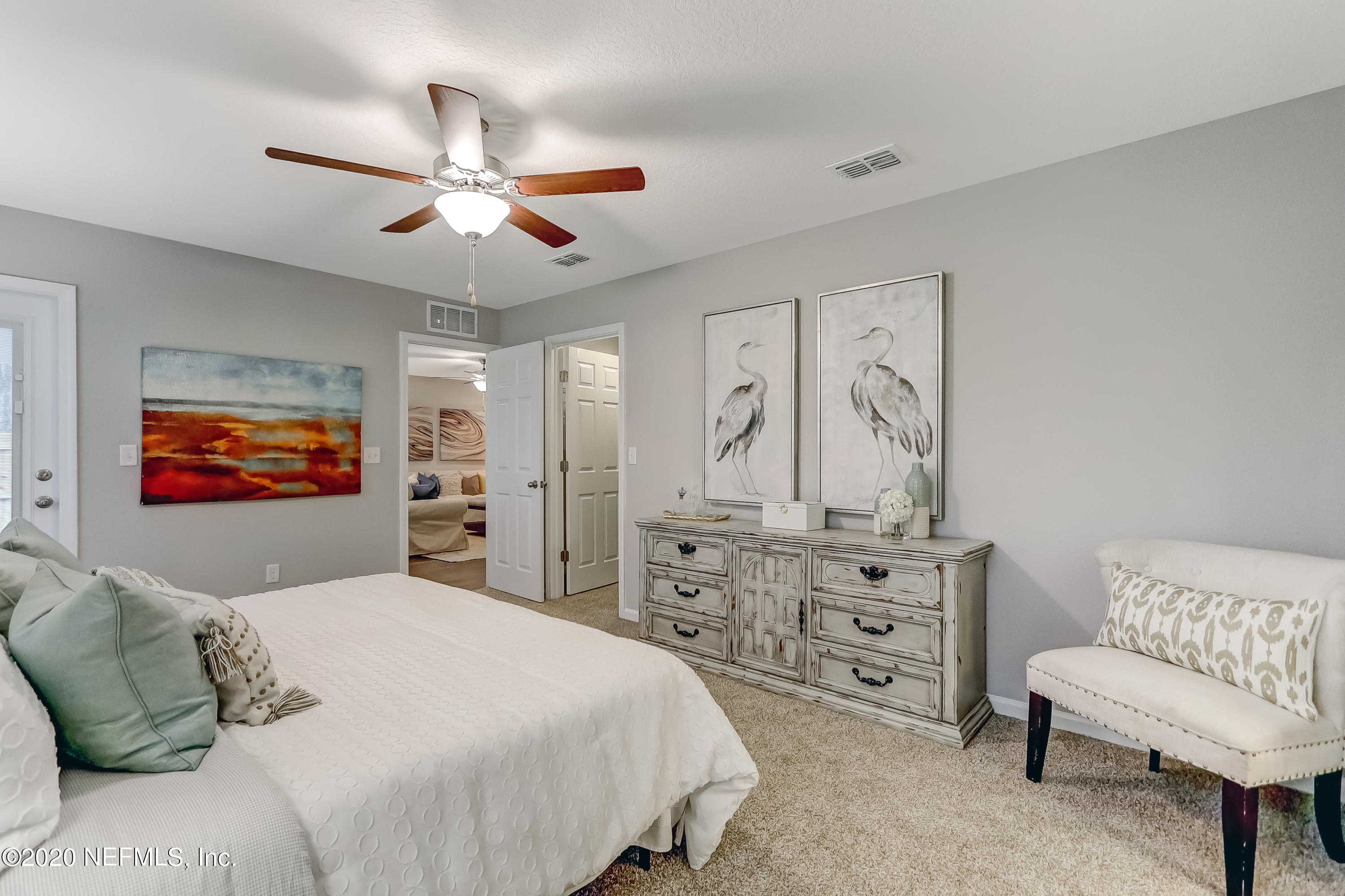 5422 Kennerly Road Jacksonville, FL 32207 - Photo 32 of 41 a bedroom with a bed a couch and a chandelier