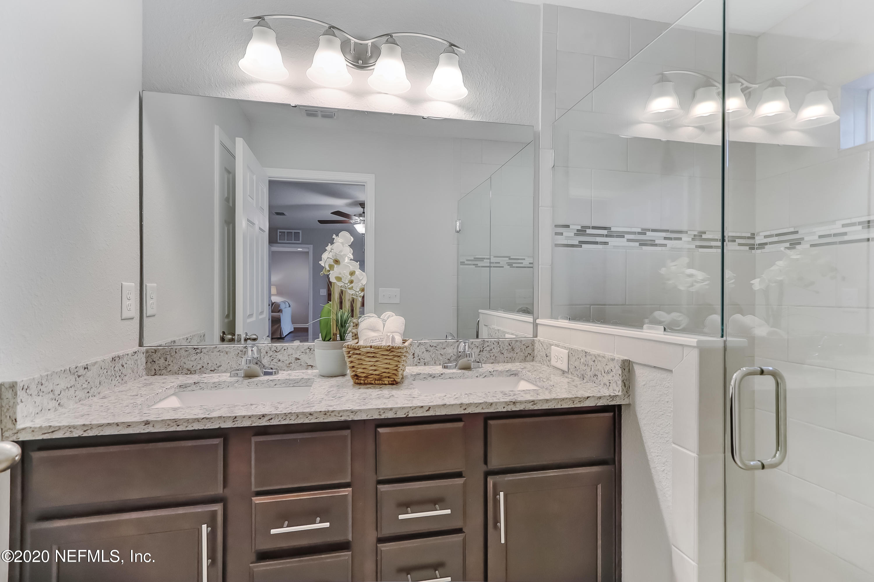 5422 Kennerly Road Jacksonville, FL 32207 - Photo 33 of 41 a bathroom with a granite countertop sink a mirror and shower