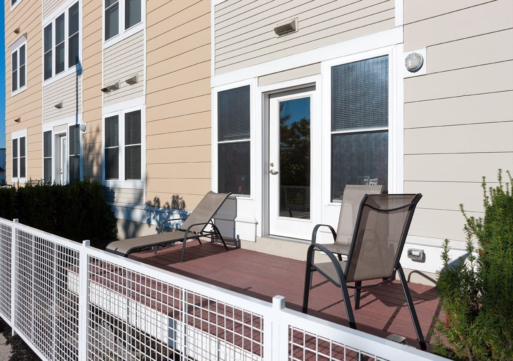 a view of two chairs and table in the balcony