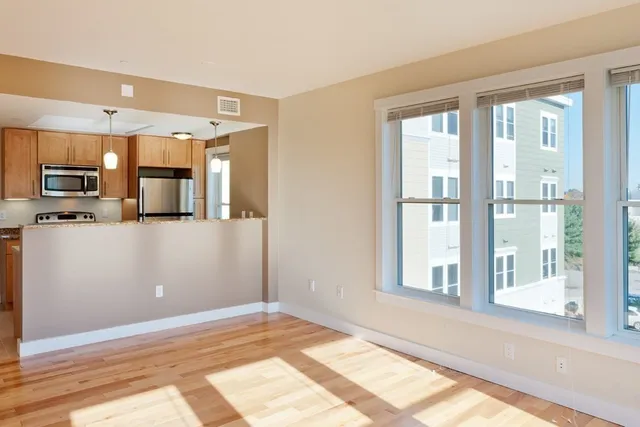 a view of a kitchen with a sink and dishwasher with wooden floor