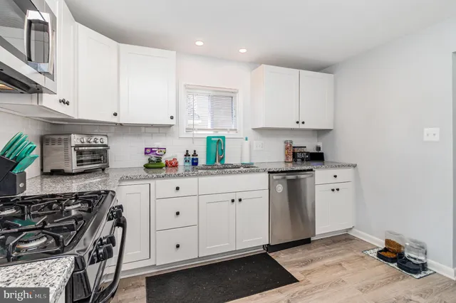 a kitchen with stainless steel appliances granite countertop a sink stove and cabinets