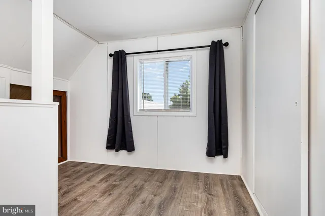 a living room with a bed furniture and a refrigerator