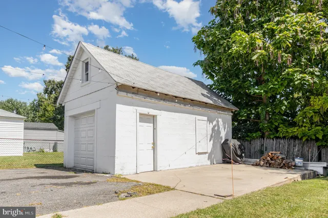 a view of a small house with wooden fence
