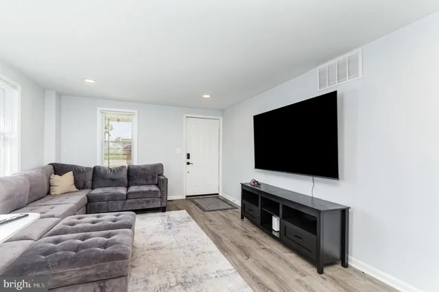 a living room with a flat screen tv a couch and a flat screen tv