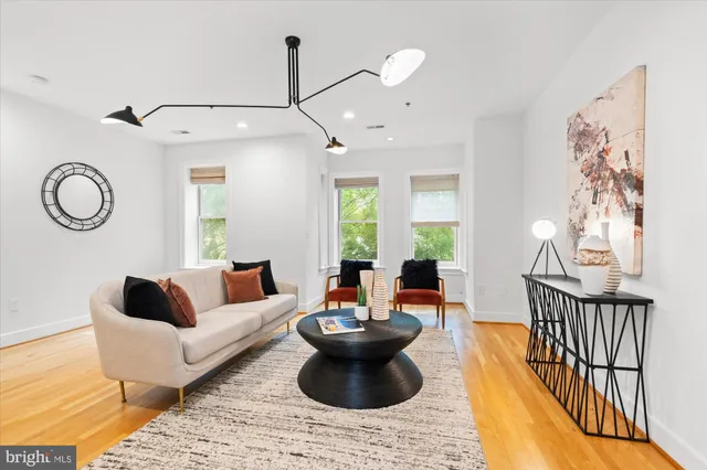 a living room with furniture a chandelier and a rug