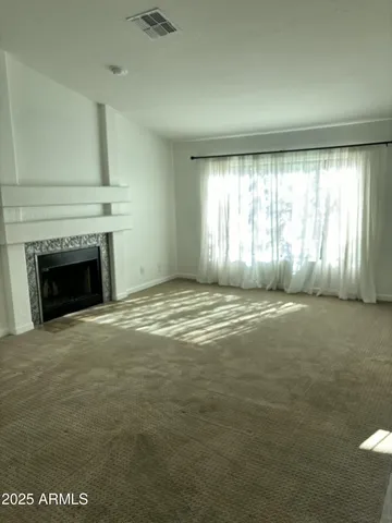 a view of an empty room with a fireplace and a window