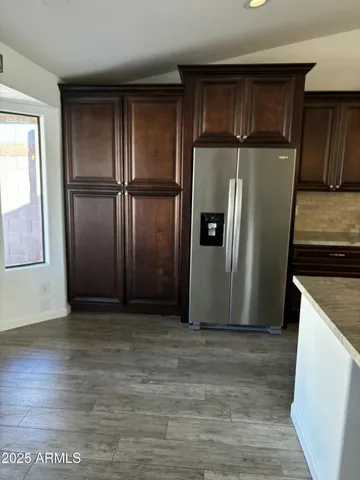 a view of a kitchen with wooden floor and a refrigerator