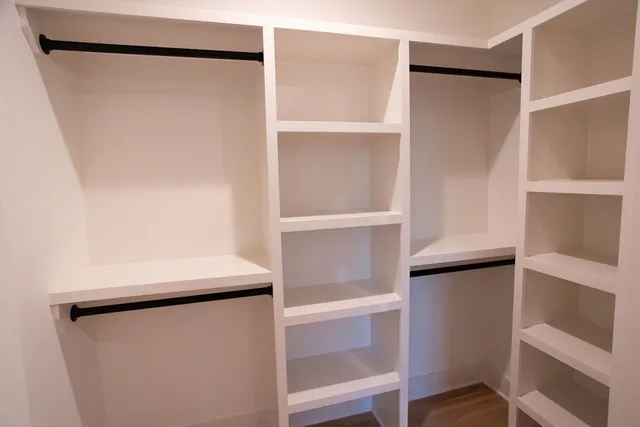 a view of walk in closet with empty racks