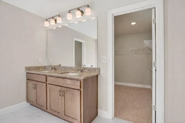 a bathroom with a granite countertop sink a large mirror and a vanity
