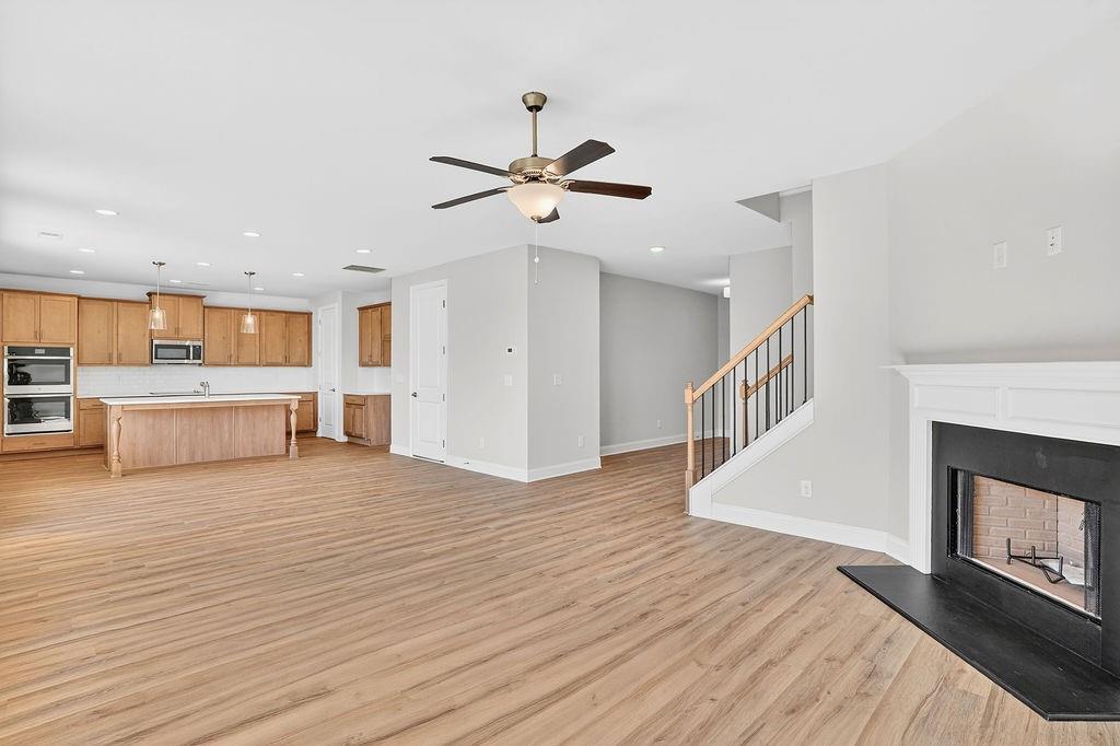 152 Classic Overlook Homer, GA 30547 - Photo 5 of 36 a view of a kitchen and an empty room with wooden floor a fireplace