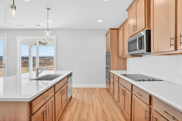 a kitchen with granite countertop a sink stove and cabinets