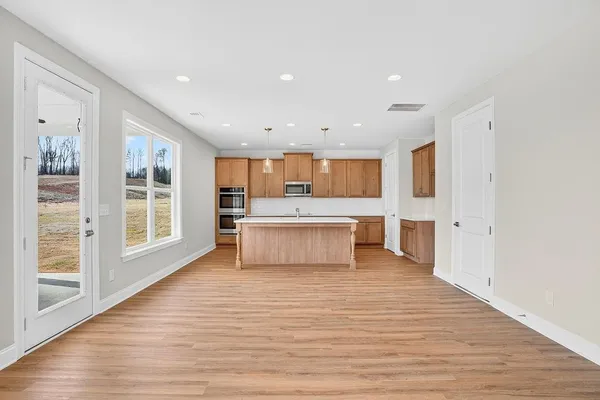 a large white kitchen with a large window a oven and a counter space