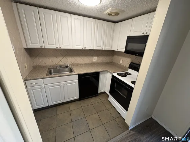 a kitchen with a stove top oven sink and cabinets