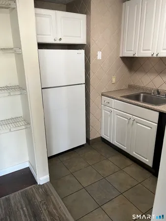 a white refrigerator freezer and a stove sitting inside of a kitchen