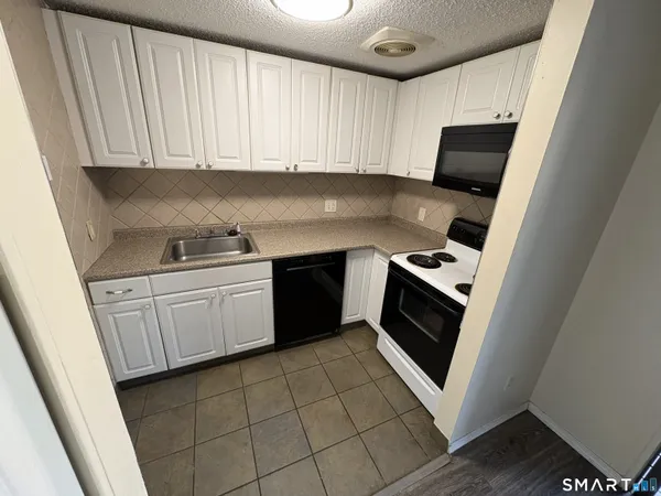 a kitchen with a stove top oven sink and cabinets