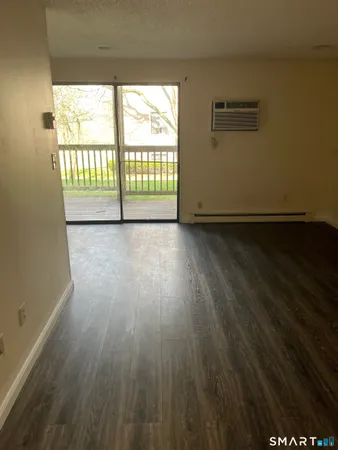 a view of a room with wooden floor and a window
